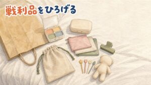 ベッドの上に広げた買い物の中身を真上から見た図。4マスのピルケース、フタつきの石けんケース、ジッパーバッグ、袋止めクリップ、巾着、弁当用ピック、小さなぬいぐるみと紙袋