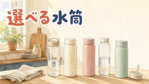 朝の窓辺のキッチンカウンターに並ぶ、無地の水筒5本。透明のクリアボトル2本と、クリーム・ピンク・ミントのステンレスタンブラー3本。手前にストロー付きのふたとたたんだ布
