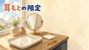 窓辺の化粧台。トレーに無地の丸い小さなパッチの台紙が置かれ、奥に丸い卓上鏡、隣にスタッドピアスとヘアクリップ、たたんだ布が並ぶ