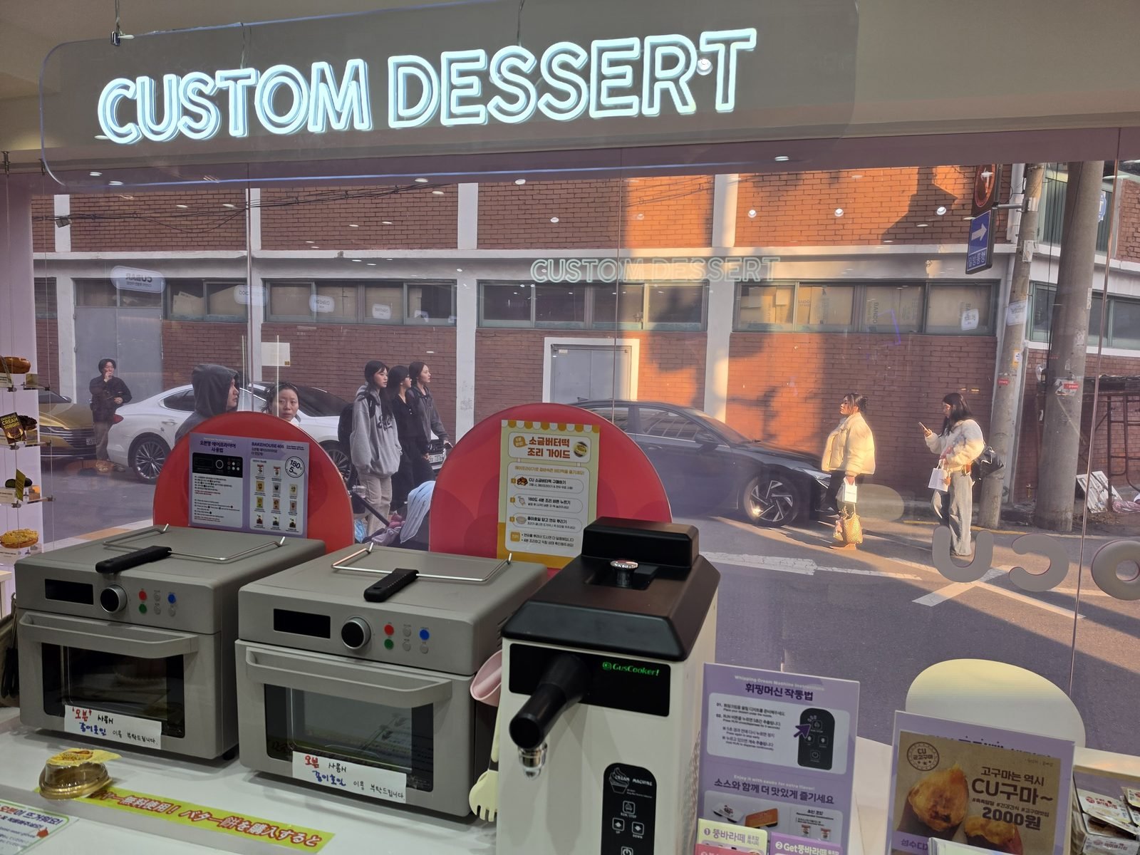 CUSTOM DESSERTのネオン看板の下に調理機が並ぶカウンター