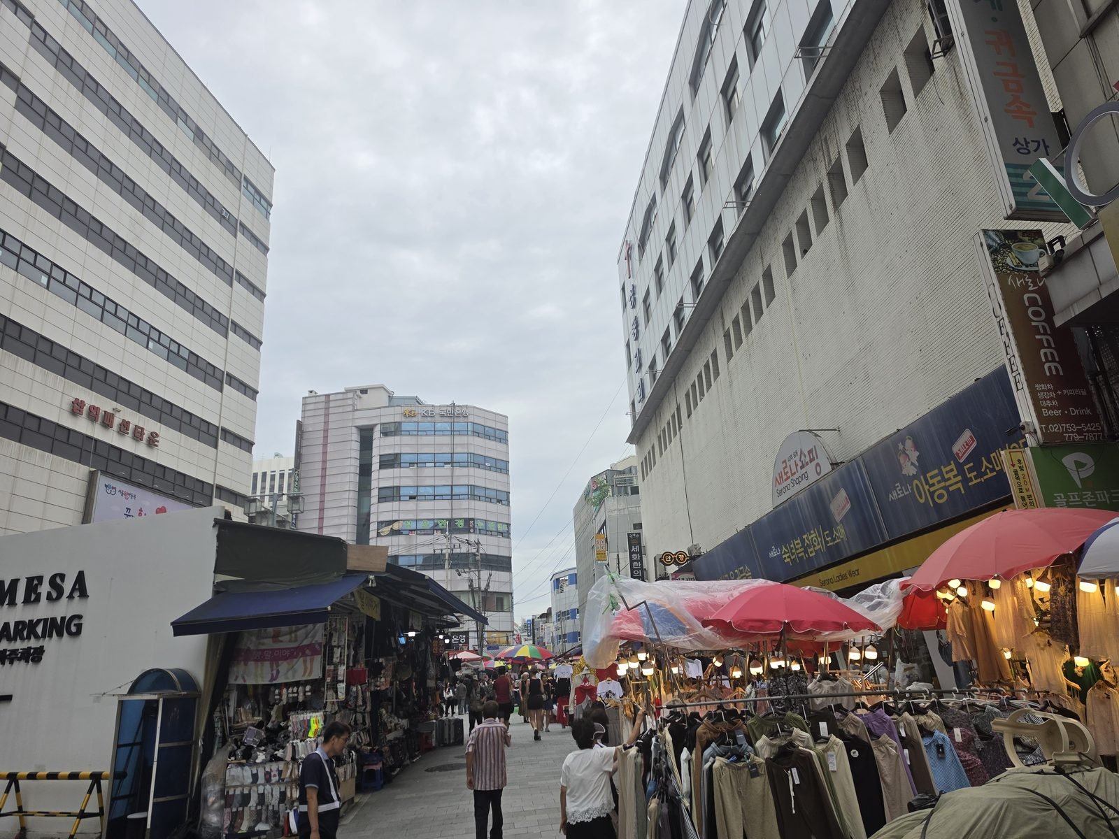 南大門市場の通りの入口にある駐車場の看板と露店の列
