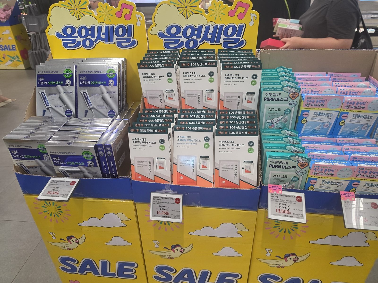 オリーブヤングのオリヤンセール看板と電子値札つきの箱の売り場