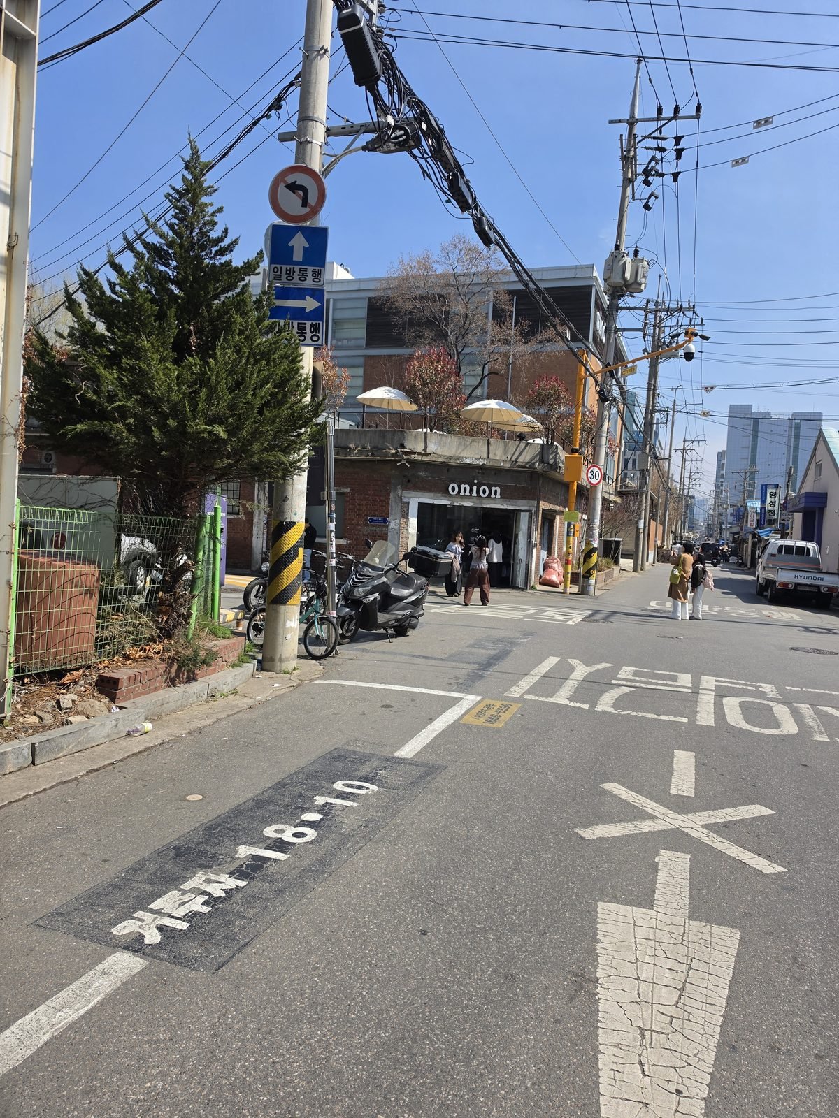 電柱と電線が走る細い通りの先にonionの看板が見える