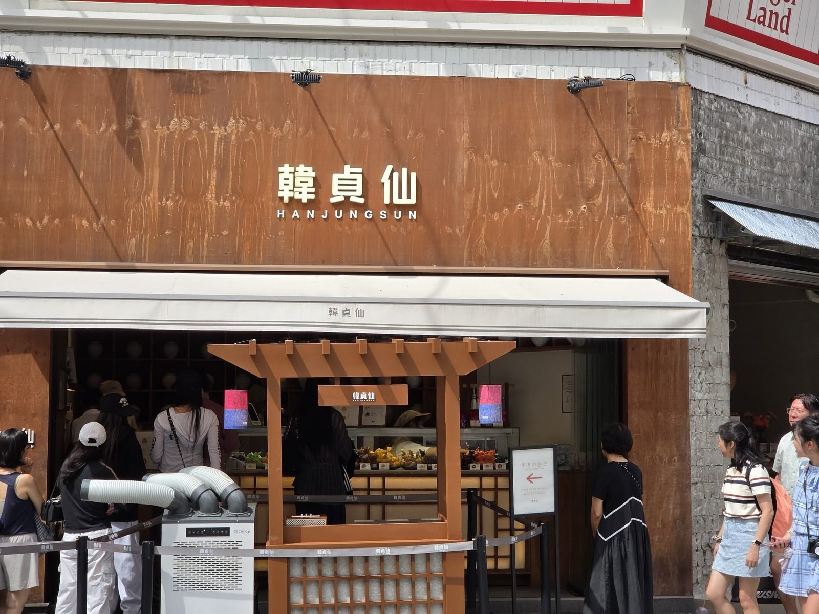 聖水の韓貞仙の持ち帰り窓口に並ぶ行列。上にBagel Landの看板