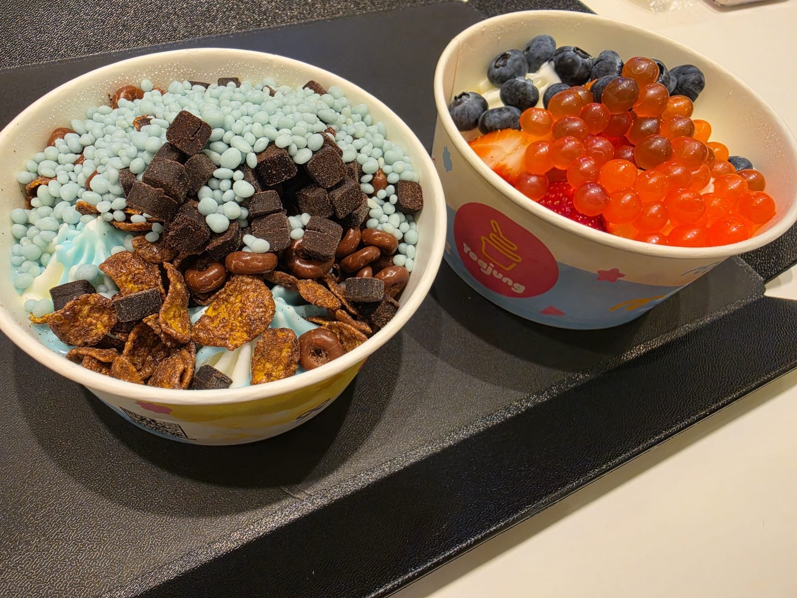 ヨーグルトアイスのボウル2つとチョコやブルーベリーのトッピング