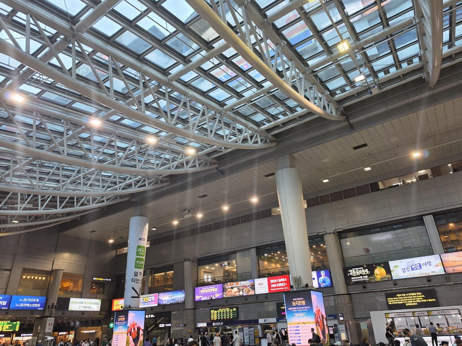 ガラス屋根の大きな駅のコンコースと案内表示